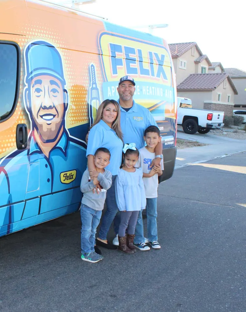 The Felix family standing in front of their wrapped service van